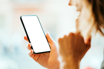 Woman in cafe holding blank white phone. Mockup empty background