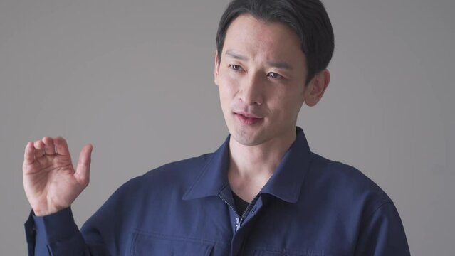 話をする作業着を着た日本人男性