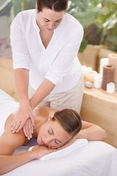 This is perfect relaxation. An attractive young woman having a massage at the spa.