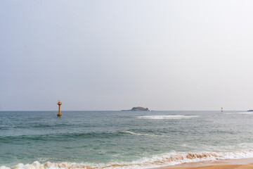 Cloudy day, sea, yellow lighthouse.
