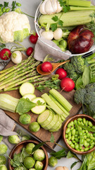 Raw and fresh spring vegetables on light background.
