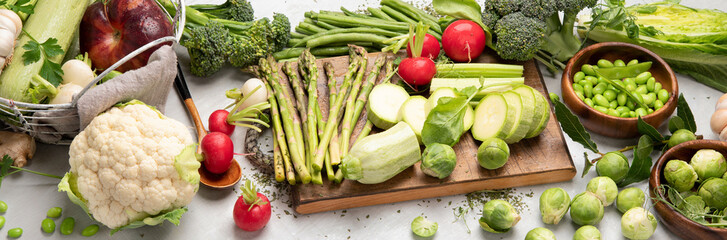 Raw and fresh spring vegetables on light background.