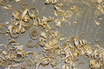 a small pile of wood shavings on a gray linoleum floor