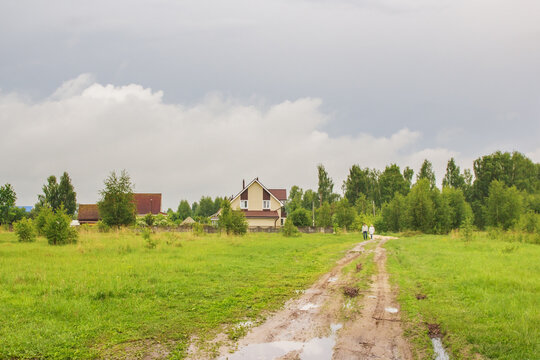 Dirt road with puddles in the village at spring