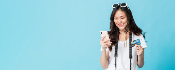 Asian pretty woman tourist preparing for travel and shopping online with smartphone and credit card...