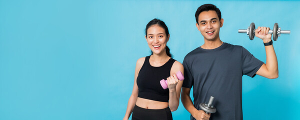 Asian beautiful happy woman holding dumbbell and standing with boyfriend are exercising isolated on...