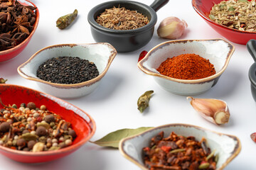 Bowls with various spices on white background