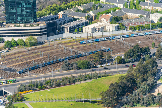 Looking down on a distant railway yard with many railway lines and metropolitan trains