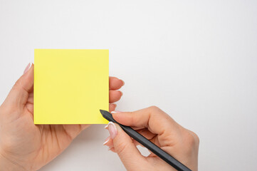 Hand written notes black pencil on yellow sticker. white table background. Mockup sticky Note...