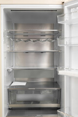 Fototapeta premium Opened empty refrigerator. Refrigerator open empty fridge inside interior. close up on empty fridge with door open. New clean refrigerator.