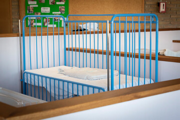 Fototapeta na wymiar Lit de bébé protégé dans une salle de formation en soin.