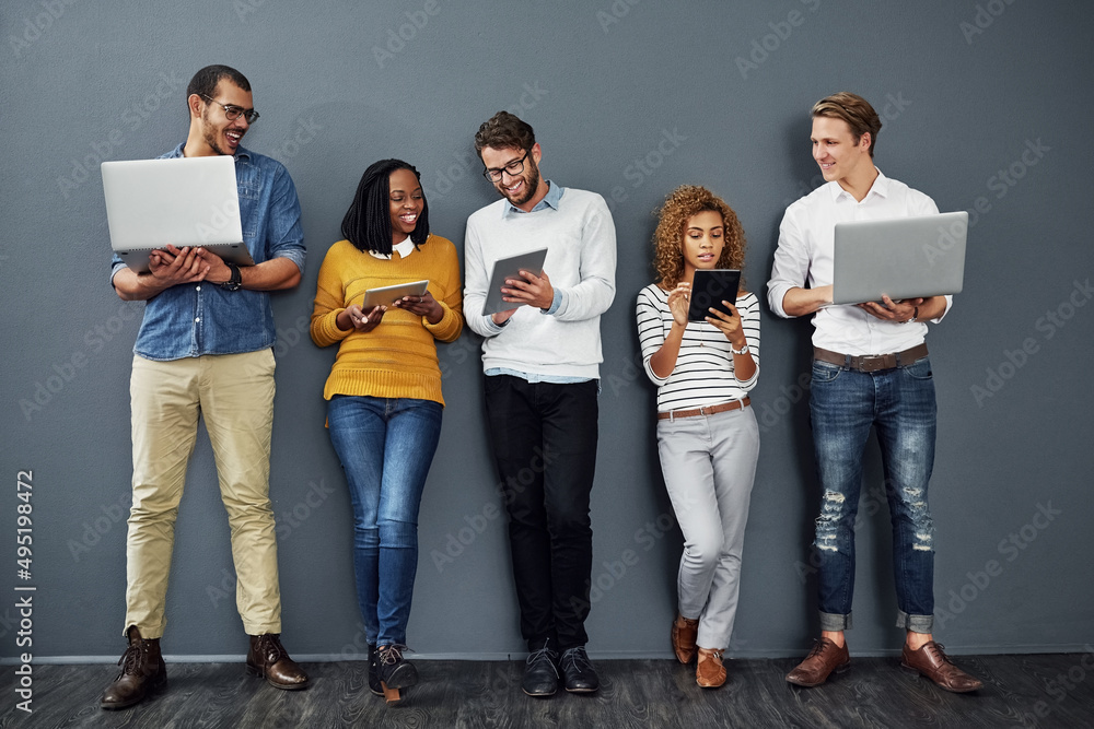 Poster Wireless technology works anywhere. Full length shot of a group of businesspeople using tablets and notebooks while waiting in line for a job interview.