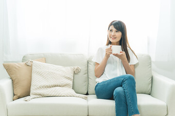 ソファに座る中高年女性（飲み物）
