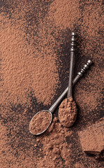 Cocoa powder in teaspoons on a dark background.