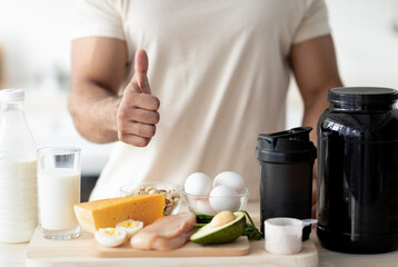 Unrecognizable sporty man showing thumb up, recommending healthy nutrition for muscle gain or...