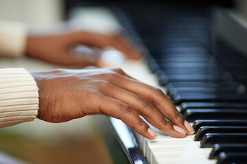 Obraz premium Close-up of female hands playing the piano during musical lesson