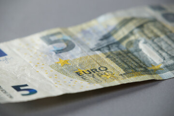 5 euro banknote close-up on a gray table. Soft focus