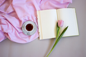 Pink tulips on wooden background. Open book, craft gift box and coffee. Mothers Day, Women Day, floral desing