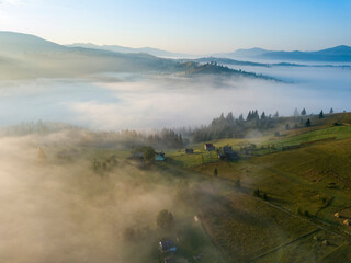 Green mountains of the Ukrainian Carpathians in the morning mist. Aerial drone view.
