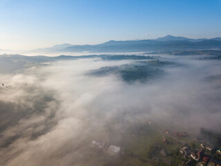 Green mountains of the Ukrainian Carpathians in the morning mist. Aerial drone view.