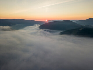 Fototapeta premium Sunrise over the fog in the Ukrainian Carpathians. Aerial drone view.