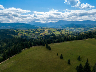 Green mountains of Ukrainian Carpathians in summer. Coniferous trees on the slopes. Aerial drone view.