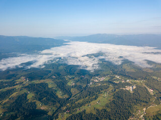 High flight in the mountains of the Ukrainian Carpathians. Fog in the valley. Aerial drone view.