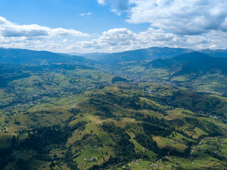 Naklejka premium Green mountains of Ukrainian Carpathians in summer. Coniferous trees on the slopes. Aerial drone view.