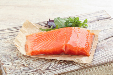 Raw salmon fillet over board