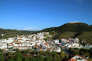 El pequeño pueblo de Sanlúcar de Guadiana en Andalucía, España. Paisaje del pueblo con sus casas encaladas, el río Guadiana y el castillo de San Marcos en lo alto de una colina colindante.