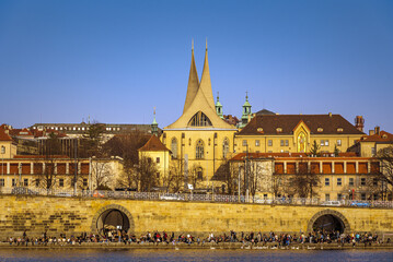 Crowded Prague embankment with renovated dungeons in Prague, The Emmaus Monastery (Czech: Emauzy or Emauzský klášter).