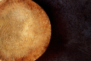 half circle cutting board for cooking on dark concrete backdrop.