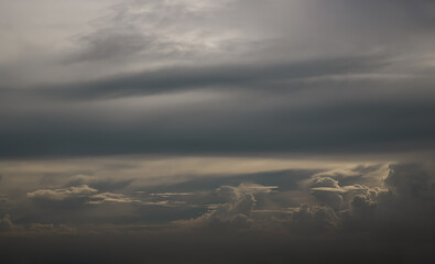 Obraz premium The sun shines through the clouds in the evening sky with dramatic light. The shape of the clouds evokes imagination and creativity, They can be used as wallpaper. No focus, specifically.