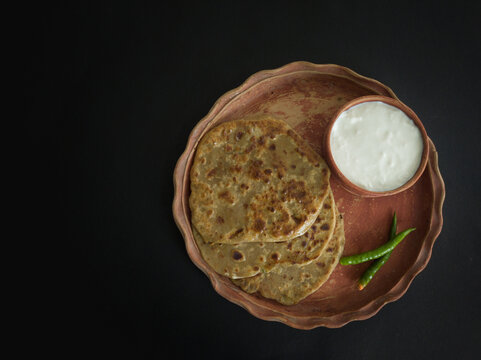 aloo paratha with curd served on plate. Traditional north indian food.