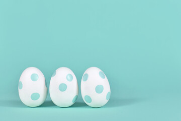Three easter eggs with dots on mint green background