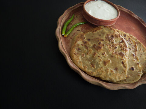 aloo paratha with curd served on plate. Traditional north indian food.