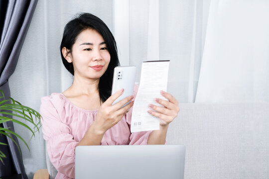 Asian Woman Scanning Qr Code To Pay Bill Online By Smartphone , Pay From Home Concept