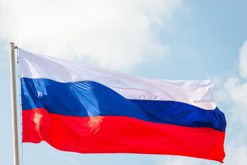 Russia flag is waving in front of blue sky