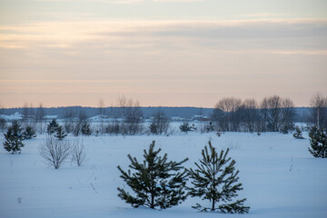Winter evening landscape, beautiful view of the countryside. Sunset sky over the horizon.
