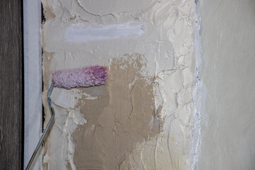 The builder applies a primer to the walls. The painter applies a primer with a roller, makes...
