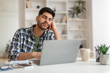 Exhausted Young Man Sleeping At Work Sitting At Desk - obrazy, fototapety, plakaty