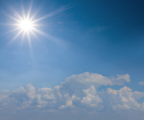 Naklejka na ściany i meble sparkle sun on blue cloudy sky background