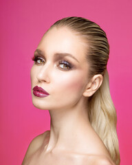 Fototapeta premium Closeup front portrait of young woman with makeup, hair straightened, isolated purple background.