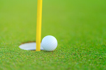 Golf ball on lip of cup at golf court