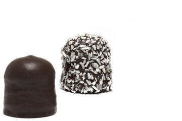 two coated chocolate marshmallows closeup white background