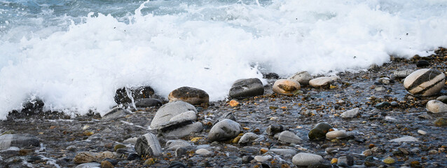 Variation de galets dans vagues et écume, 