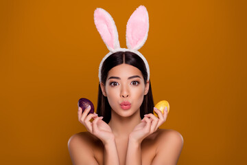 Closeup photo of brunette asian ethnicity girl wear easter hare ears hold painted eggs send air kiss isolated pastel background