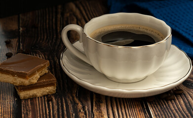 Black coffee with caramel squares with coffee beans