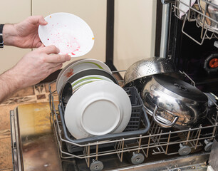 a man loads dirty dishes into the dishwasher