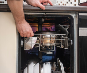 a man loads dirty dishes into the dishwasher